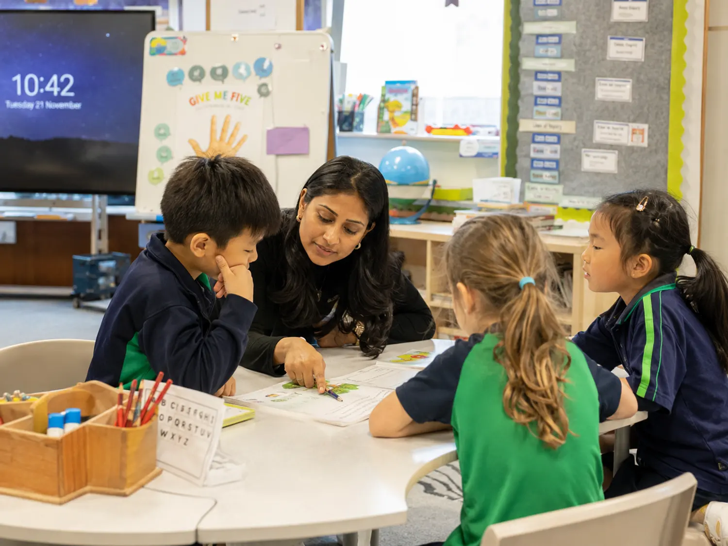 A teacher working through a problem with a small group
