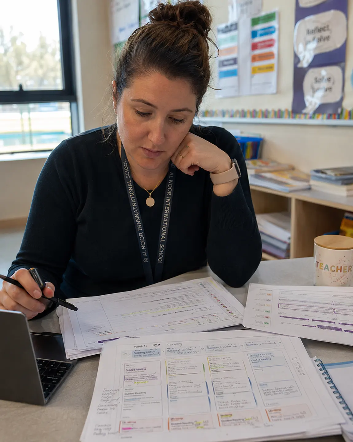 A teacher mapping out the week's lessons at her desk